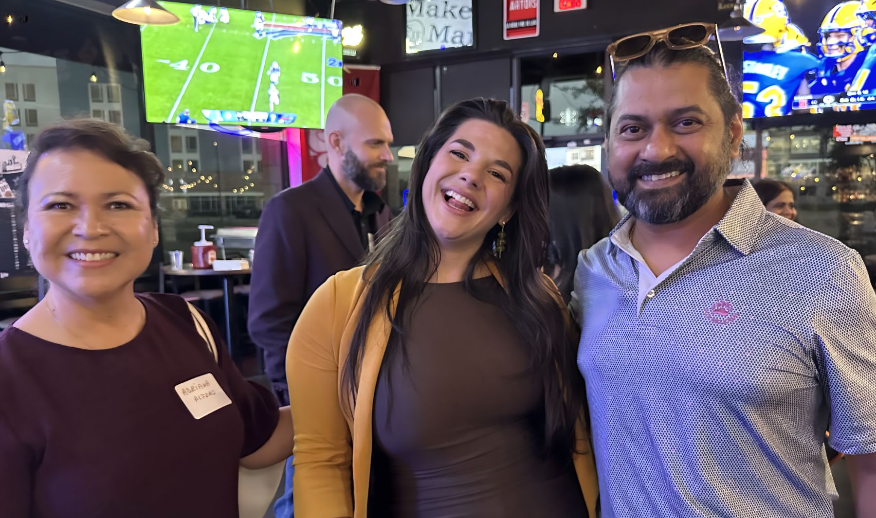 Three smiling attendees at a Mind & Machine DFW event